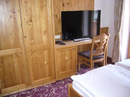 派廷格普法芬温克尔阿尔卑斯山酒店的一间卧室配有一张桌子、一台电视和一把椅子