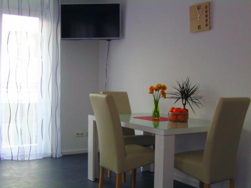 莱因费尔登-埃希特尔丁根莫特姆噶斯特公寓的餐桌、椅子和花瓶