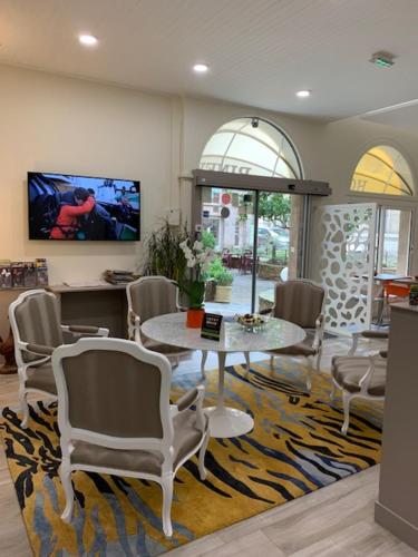 罗德兹比内酒店的一间位于地毯上的客厅,配有桌椅