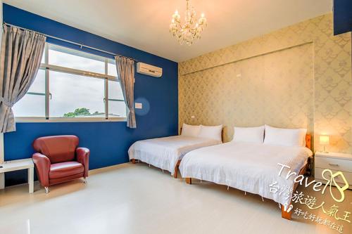 台东时尚玩家民宿的一间卧室设有两张床、一把椅子和一个窗户。