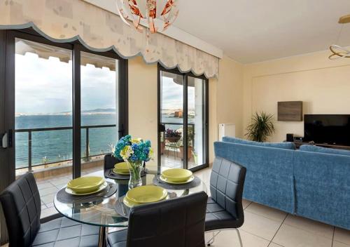 塞萨洛尼基Seafront Family Apartment & free parking, the Cruiseflat的一间带桌椅和沙发的用餐室