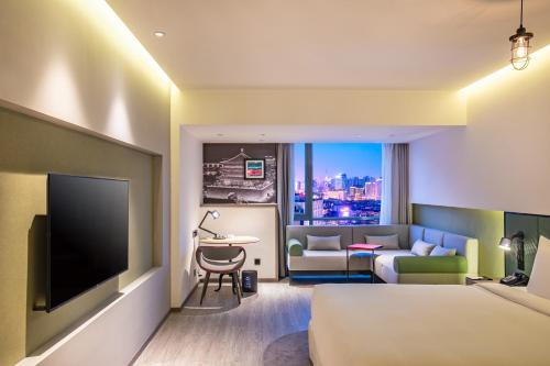西安西安金茂酒店(钟鼓楼回民街店)的酒店客房配有1张床、1台电视和1张沙发。