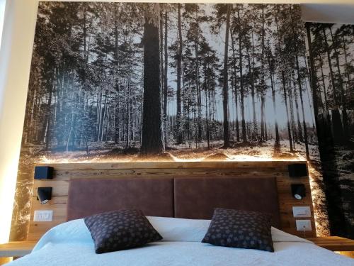 莱德罗Albergo Silvana的卧室的墙上挂有森林壁画