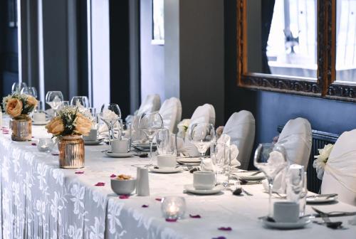 因弗内斯摩尔峡谷酒店的长桌,带白色桌子和椅子及眼镜