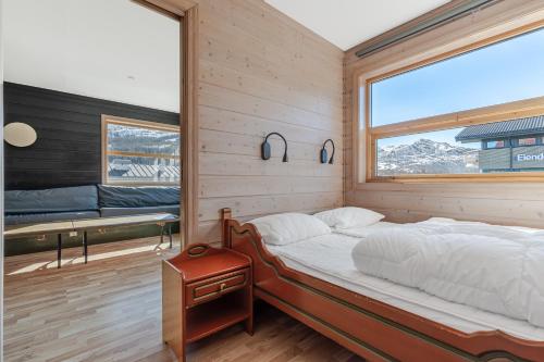 海姆瑟达尔Skiers Lodge 2 - Saga Apartments的一间卧室设有一张床和一个大窗户