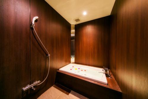 Shimo-kogaKumamoto Hotel Christmas Forest Garden (Love Hotel)的木墙内带浴缸的浴室