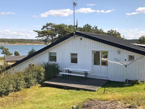 Åskloster6 person holiday home in skloster的白色的建筑,木甲板上设有长凳