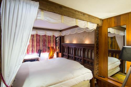 奥登布尔格德斯托克酒店的卧室配有带白色床单的天蓬床
