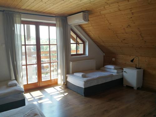 莫悠罗德Manoka Guest House的阁楼卧室设有两张床和窗户。