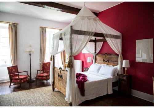 圣昂托南La Résidence Chambre d'Hotes的一间卧室配有一张带红色墙壁的天蓬床