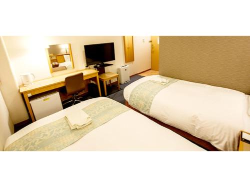 福冈Hakata Floral Inn Nakasu / Vacation STAY 80214的酒店客房配有两张床和一张书桌