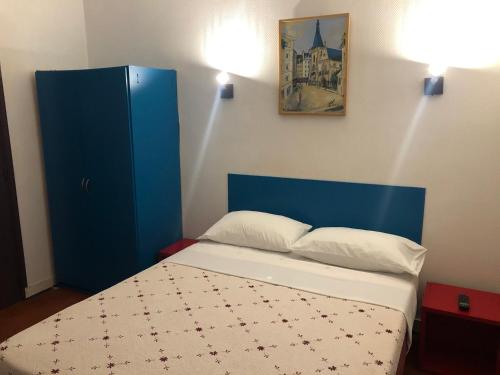 勒瓦卢瓦-佩雷舍瓦利尔酒店的一间卧室配有蓝色橱柜和一张床