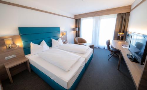 圣珀尔滕大都会酒店的酒店客房,配有床和电视