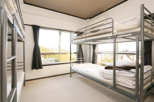 伊东荘荘旅馆的一间卧室设有双层床和窗户。