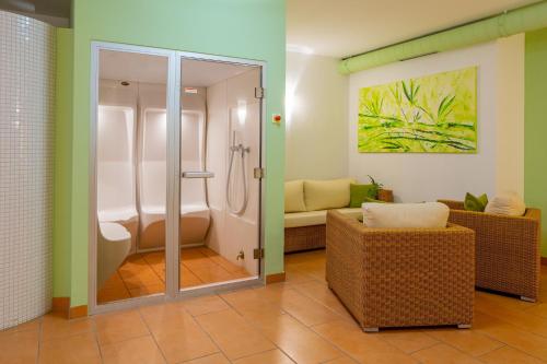 魏森多夫ACANTUS Hotel的一间带淋浴的浴室和一张沙发。
