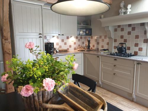 ReeuwijkHet Stalhuys的厨房配有带粉红色花卉的桌子