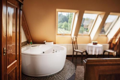 Sankt Nikolai im SausalWeingartenhotel Harkamp Südsteiermark的一间位于客房内的带大型白色浴缸的浴室