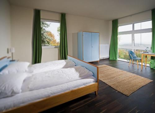 Sankt Nikolai im SausalWeingartenhotel Harkamp Südsteiermark的一间卧室配有一张床、一张书桌和窗户。