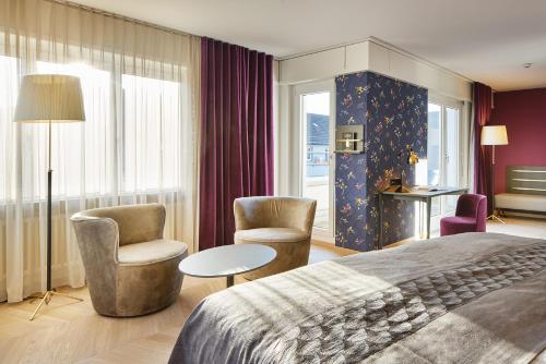苏黎世泽费尔德速乐酒店的酒店客房配有一张床、两把椅子和一张桌子