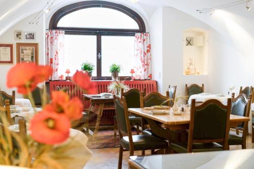 萨尔茨堡沃尔夫酒店的餐厅设有桌椅和窗户。