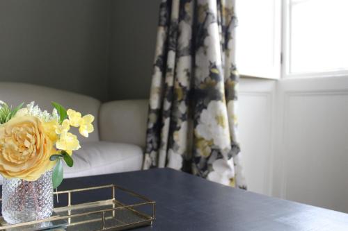 科克茅斯Dovenby Apartment- great base for exploring Lake District的花瓶和窗户的桌子