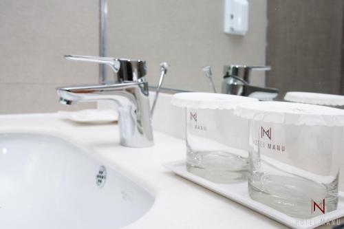 首尔首尔马努酒店的一个带水槽和玻璃的浴室台面