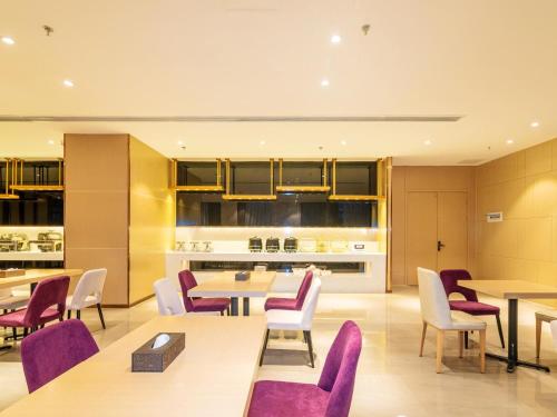 安顺麗枫酒店·贵州安顺西高铁站店的一间带桌子和紫色椅子的用餐室