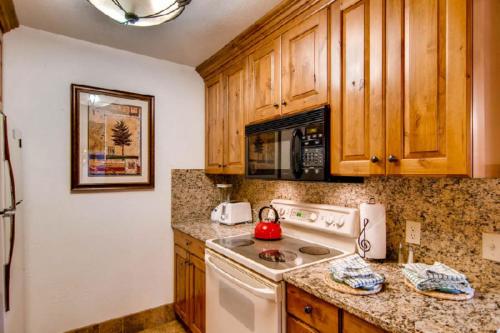 范尔Eagle Point Resort的厨房配有木制橱柜和白色炉灶烤箱。