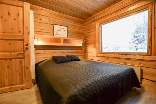 HyrynsalmiLoma-Laattaja的小木屋内一间卧室,配有一张床