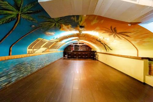 美因茨哈瓦那酒店的墙上挂着棕榈树壁画的走廊