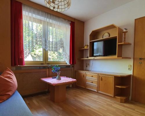 GallspachLandgasthof Waldesruh的客厅配有电视和桌子