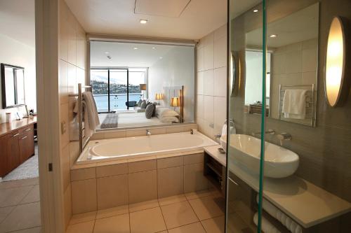 皇后镇里斯酒店&豪华公寓的带浴缸、水槽和镜子的浴室