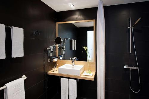 柏林NH酒店波茨坦广场店的一间带水槽和镜子的浴室