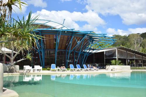 弗雷泽岛翠鸟湾度假酒店的一座带椅子和游泳池的建筑