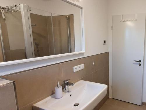 奥芬堡Haus 15的浴室设有白色水槽和镜子