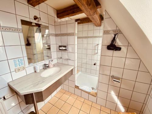 泰克山下基尔夏伊姆Stadthotel Waldhorn的浴室配有盥洗盆和浴缸。