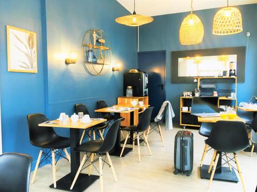 勒图凯-巴黎普拉日Hôtel Jules的餐厅拥有蓝色的墙壁和桌椅
