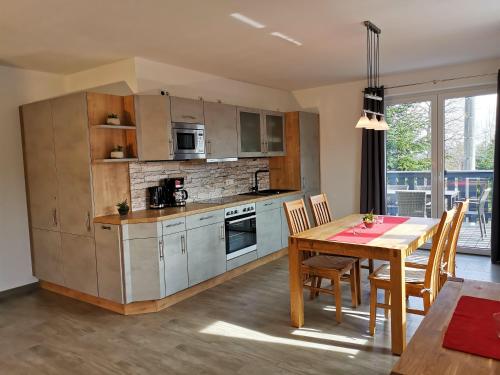 卡劳特格瑞斯赫Apartmenthaus Vetter的一间带桌子的厨房和一间餐厅