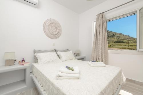 米科利维亚Orkos Naxian Wave 2的白色卧室,配有带毛巾的床