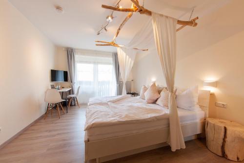 BerlingenAppartementhaus EifelAdventures的一间卧室配有一张带天蓬的床