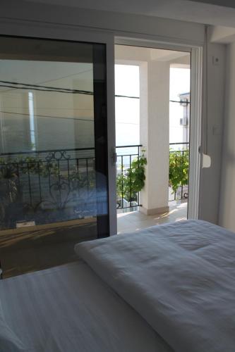 多布拉沃达Apartmani Kasija的一间卧室设有一张床,享有阳台的景色