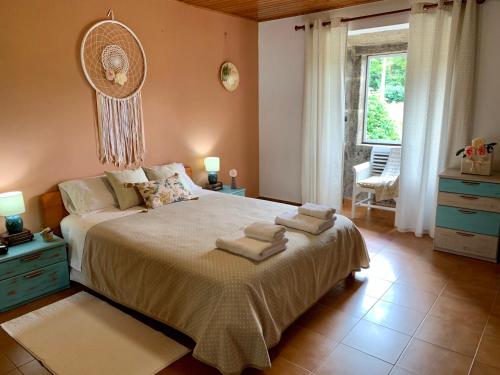 Salvatierra de MiñoCasa Quinta de Teanes的一间卧室配有一张大床和毛巾