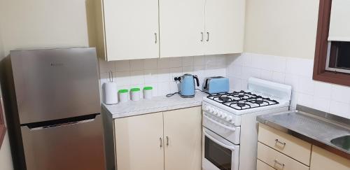 怀阿拉Warmont Apartments Self Contained Home的厨房配有炉灶和冰箱。