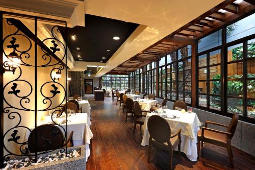 台北台北花园大酒店 - 西门町的用餐室设有桌椅和窗户。