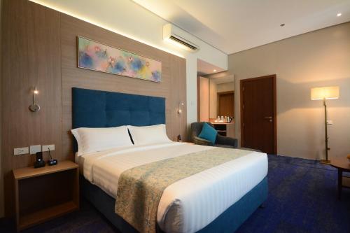达沃市Blue Lotus Hotel的酒店客房带一张大床和一把椅子