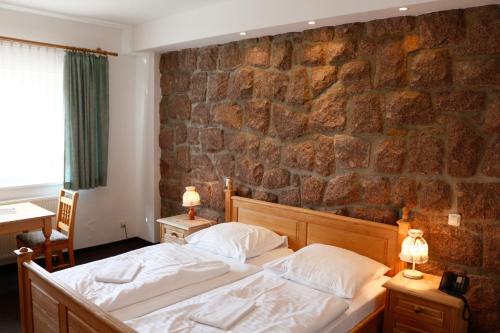 库罗阿尔滕堡卢格斯滕霍夫酒店的一间卧室设有一张床和石墙