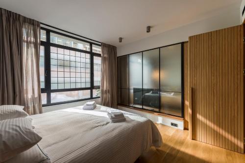 雅典Kin Athens的一间卧室设有一张大床和大窗户