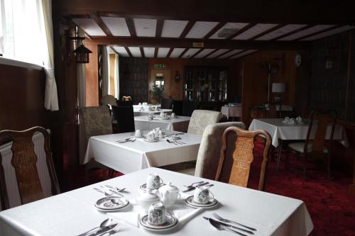 大雅茅斯盖博艾恩德酒店的餐厅配有白色的桌椅和银器