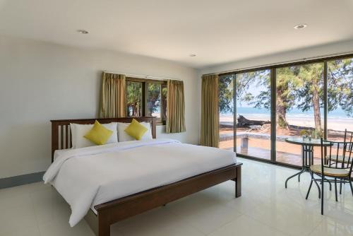 华欣Seapine Beach Golf and Resort Hua Hin的一间卧室配有一张床,享有海景