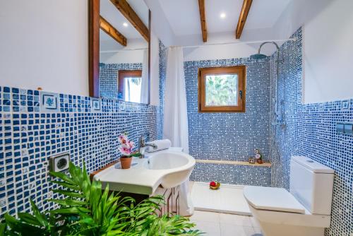 柳维Ideal Property Mallorca - Can Tomeu的蓝色瓷砖浴室设有水槽和卫生间